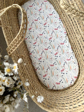 Load image into Gallery viewer, Baby moses basket with poppy and foliage print sheet on mattress