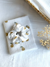 Load image into Gallery viewer, White scrunchie with gold accents on a white fabric background