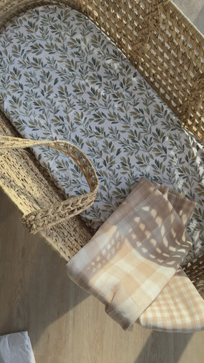 Video of double sided gingham muslin cloth over baby moses basket